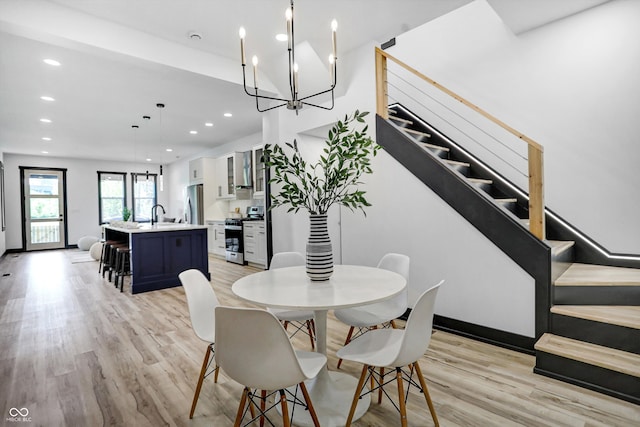 dining room featuring light hardwood / wood-style flooring, a notable chandelier, and sink