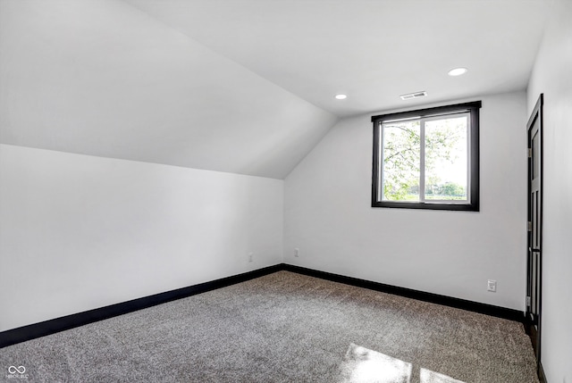 additional living space featuring carpet floors and lofted ceiling