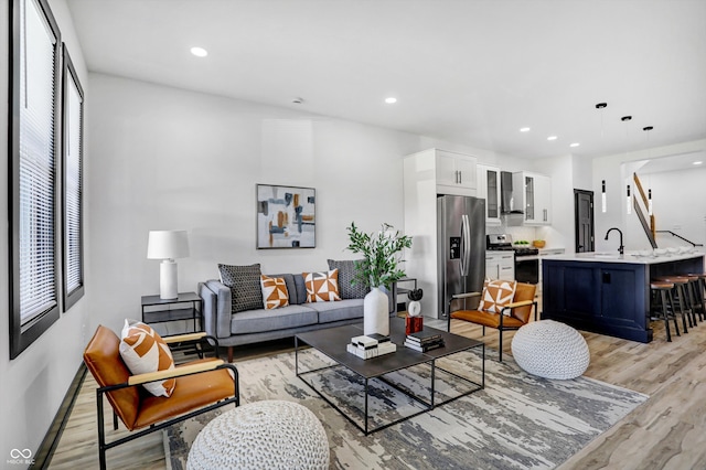 living room featuring sink and light hardwood / wood-style floors