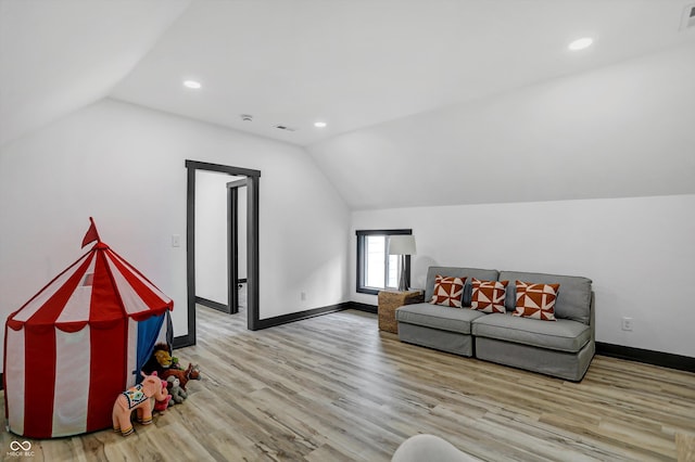 living room featuring vaulted ceiling and light hardwood / wood-style flooring