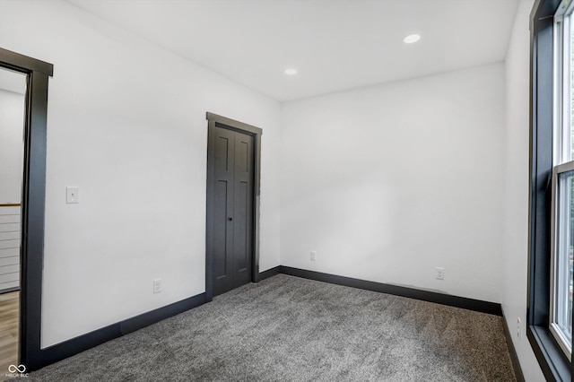 unfurnished room with dark carpet