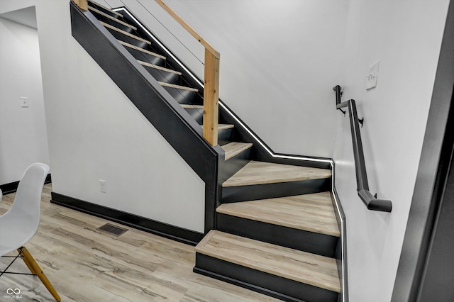 staircase with hardwood / wood-style floors