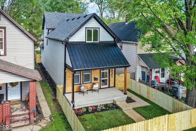 rear view of property featuring covered porch