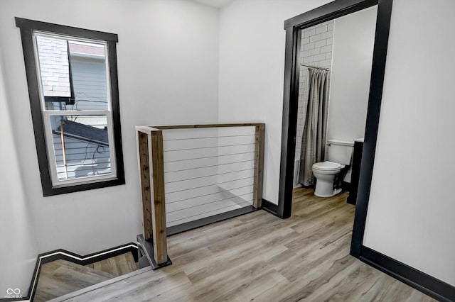 bathroom with hardwood / wood-style flooring and toilet