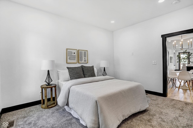 bedroom featuring carpet and an inviting chandelier