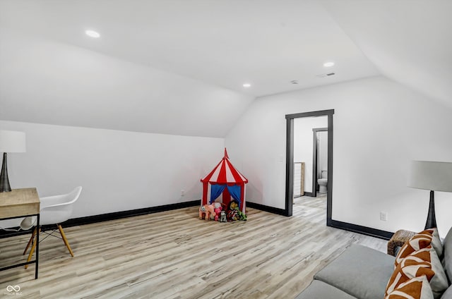 recreation room featuring vaulted ceiling and light wood-type flooring