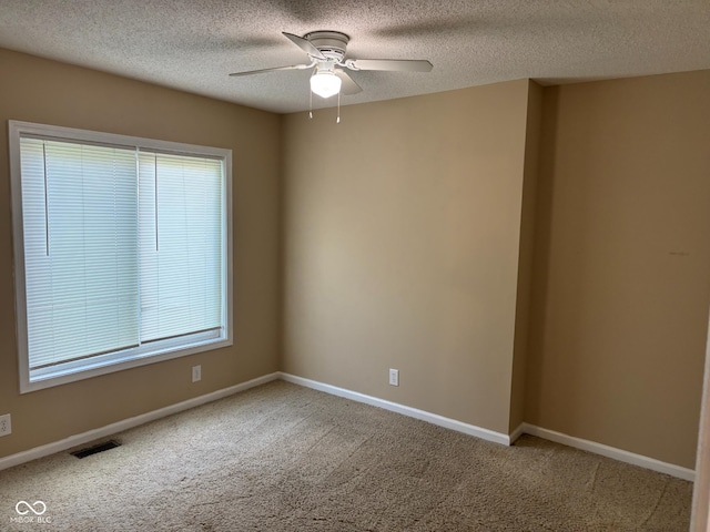 carpeted spare room featuring ceiling fan and a textured ceiling