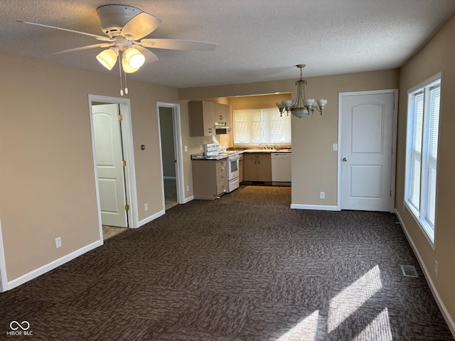 kitchen with dark colored carpet, a textured ceiling, white appliances, and ceiling fan with notable chandelier