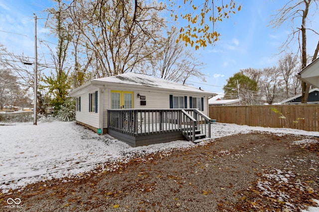 snow covered back of property featuring a deck