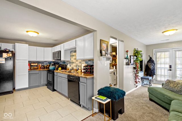 kitchen featuring black appliances, sink, gray cabinetry, and backsplash