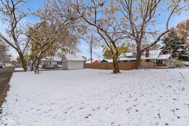 yard covered in snow with an outbuilding