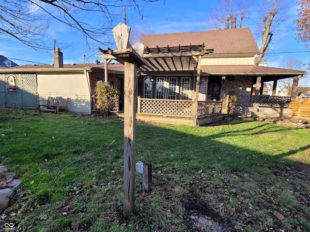 back of house with a lawn and a pergola