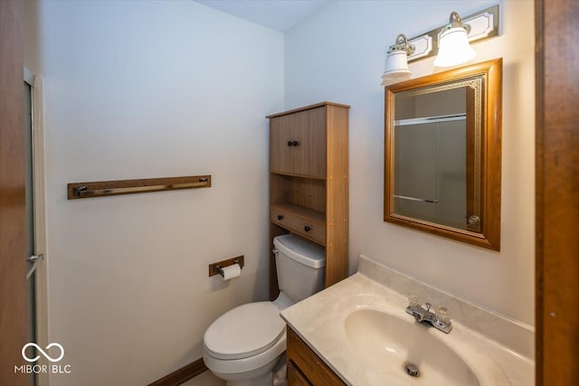 bathroom featuring vanity, toilet, and a shower with shower door