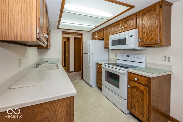 kitchen with a textured ceiling, sink, and white appliances