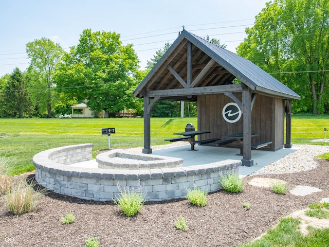 view of property's community featuring a lawn and an outdoor structure