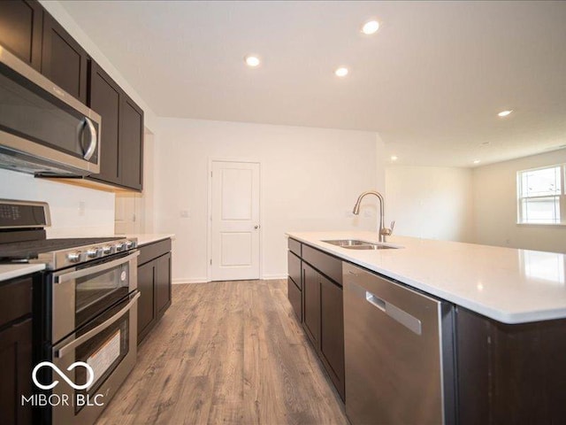 6322 Granby Dr, Whitestown, IN 46075 - kitchen with stainless steel appliances, light countertops, wood finished floors, a kitchen island with sink, and recessed lighting