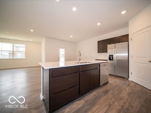 6322 Granby Dr, Whitestown, IN 46075 - kitchen featuring stainless steel appliances, dark wood-style floors, an island with sink, light countertops, and dark brown cabinets