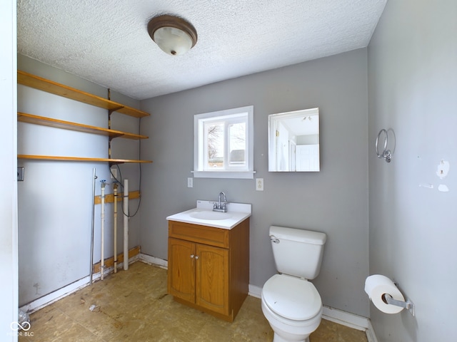 bathroom with vanity, toilet, and a textured ceiling