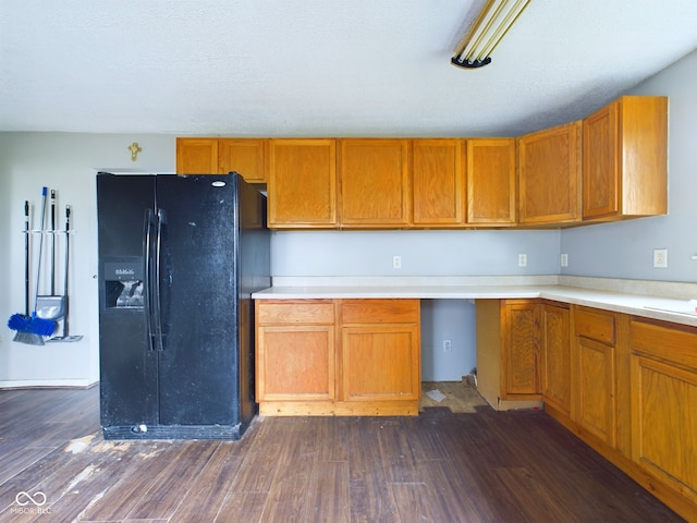 kitchen with black refrigerator with ice dispenser and dark wood-type flooring