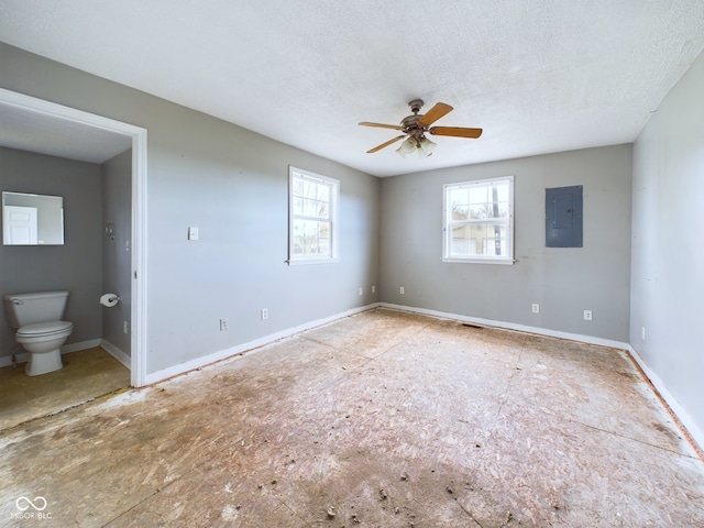 unfurnished room with ceiling fan, a textured ceiling, and electric panel