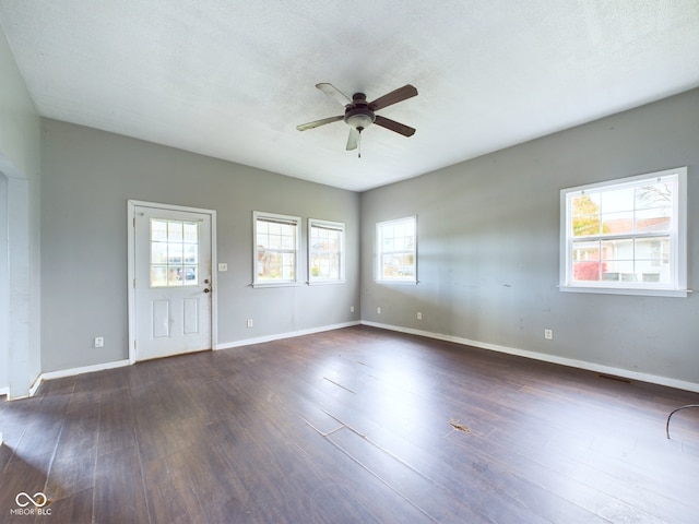 unfurnished room with dark hardwood / wood-style flooring, ceiling fan, plenty of natural light, and a textured ceiling