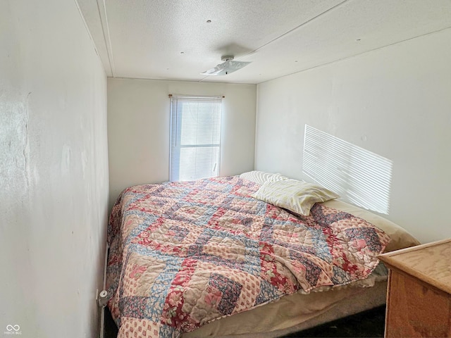 bedroom featuring ceiling fan and a textured ceiling