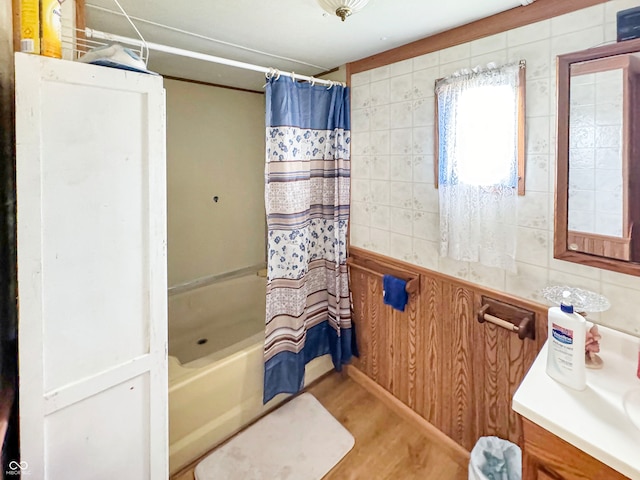 bathroom with vanity, shower / bathtub combination with curtain, and tile walls