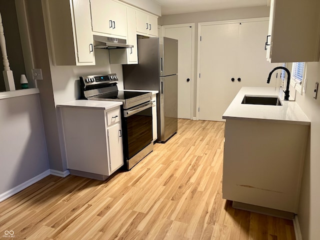 kitchen featuring white cabinets, sink, stainless steel appliances, and light hardwood / wood-style flooring