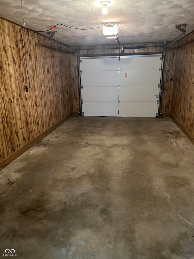 garage with wood walls and a garage door opener