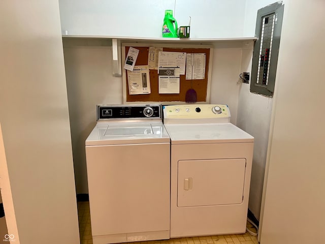 clothes washing area with washing machine and dryer and electric panel