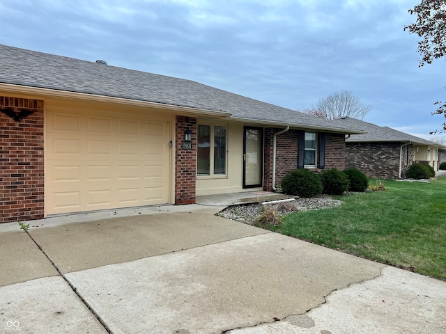 ranch-style house featuring a garage and a front lawn