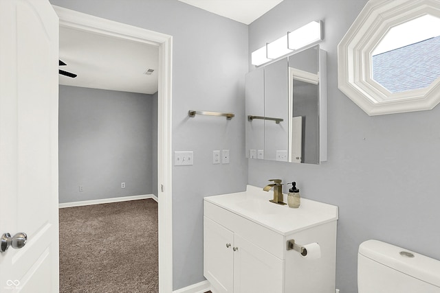 bathroom with ceiling fan, vanity, and toilet