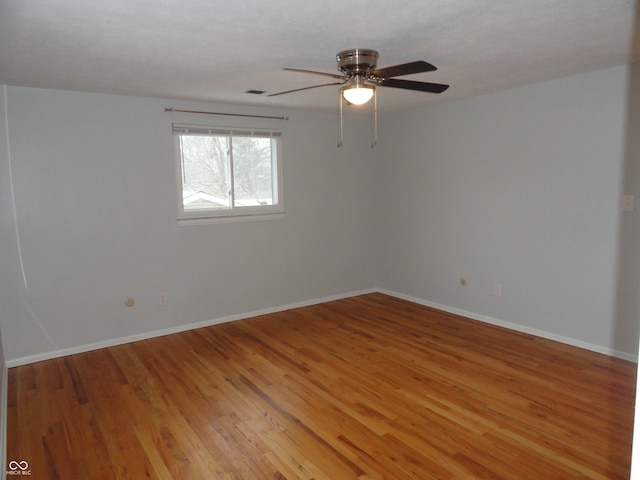 empty room with hardwood / wood-style floors and ceiling fan