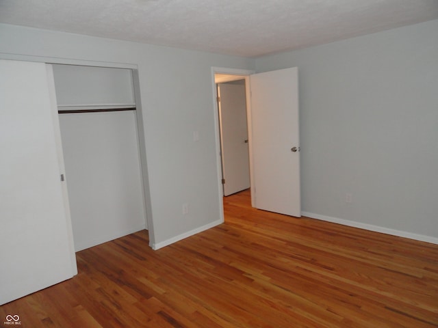 unfurnished bedroom with hardwood / wood-style flooring and a closet