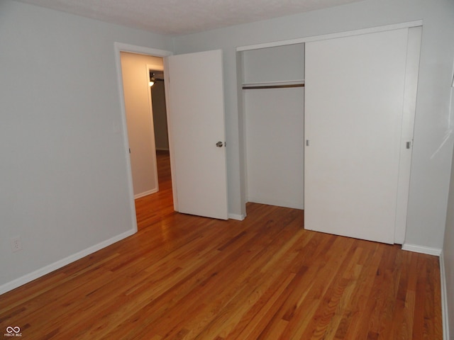 unfurnished bedroom featuring light wood-type flooring and a closet