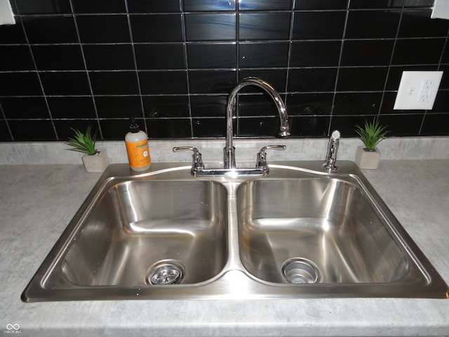 details featuring tasteful backsplash and sink