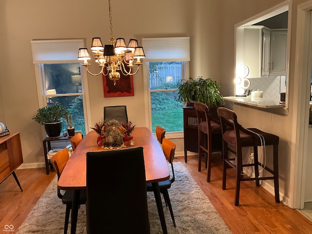 dining room with light hardwood / wood-style floors and an inviting chandelier