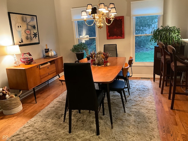 dining room featuring wood-type flooring and an inviting chandelier