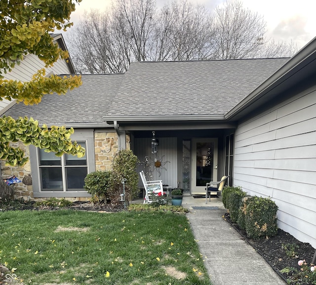 view of exterior entry featuring a lawn