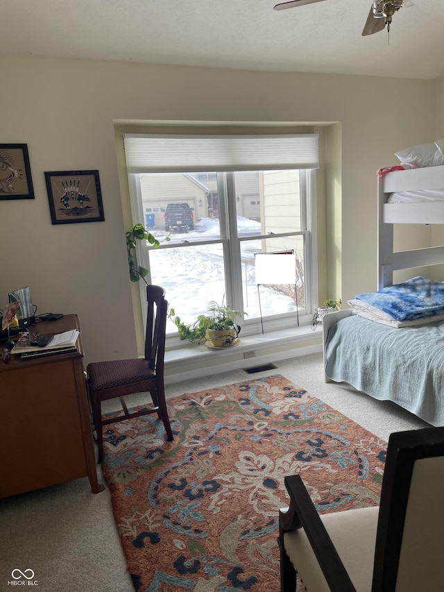 bedroom with a textured ceiling, ceiling fan, and light carpet