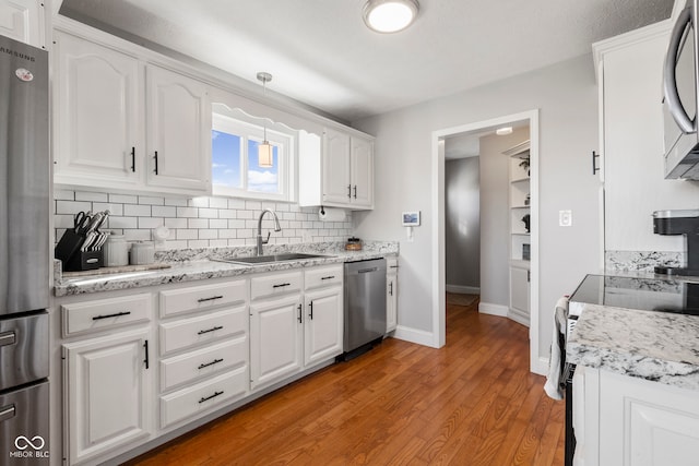 kitchen featuring white cabinets, appliances with stainless steel finishes, light hardwood / wood-style floors, and sink