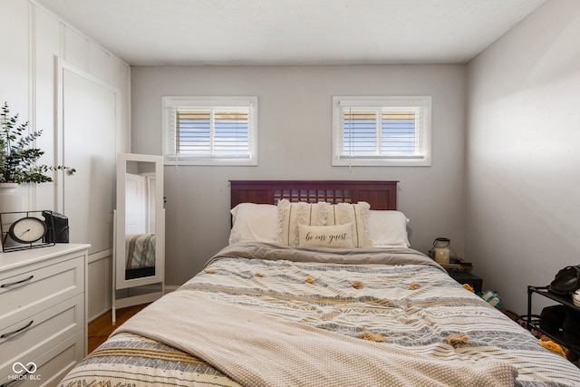 bedroom with multiple windows and hardwood / wood-style flooring