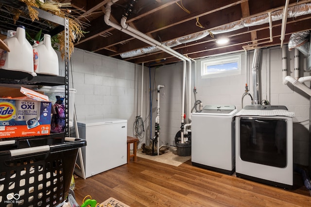 clothes washing area featuring hardwood / wood-style flooring and washer and dryer