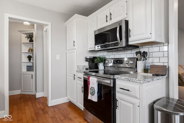 kitchen with a textured ceiling, white cabinets, stainless steel appliances, and dark hardwood / wood-style floors