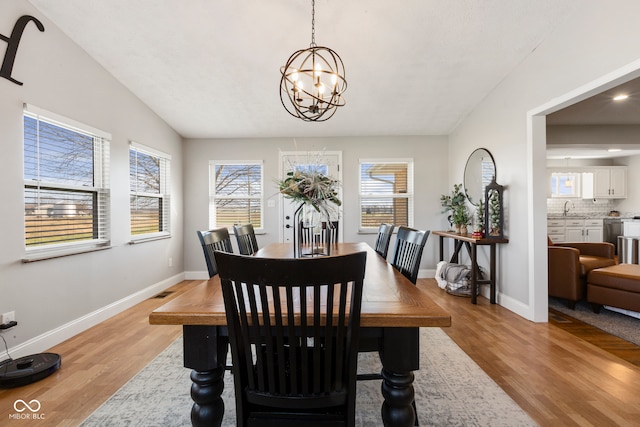 dining room featuring a wealth of natural light, light wood-type flooring, and a notable chandelier