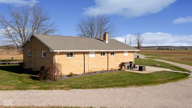 view of side of home with a yard