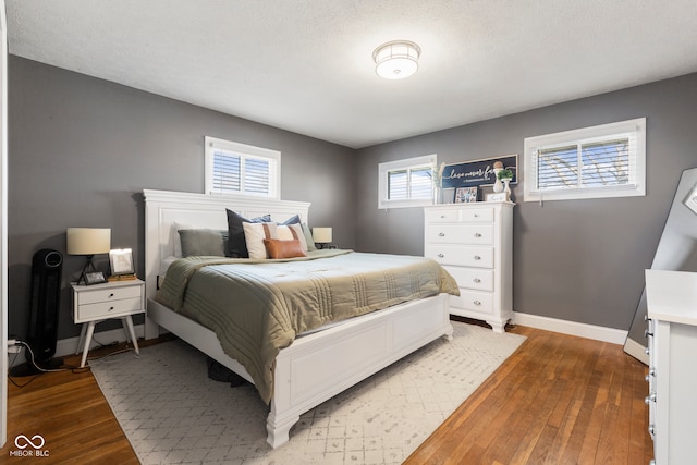 bedroom featuring hardwood / wood-style flooring and a textured ceiling