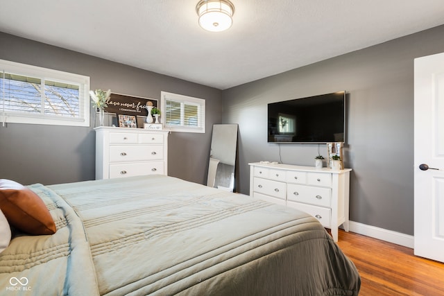 bedroom with light wood-type flooring and multiple windows