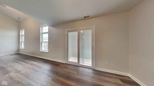 spare room with dark hardwood / wood-style floors and vaulted ceiling