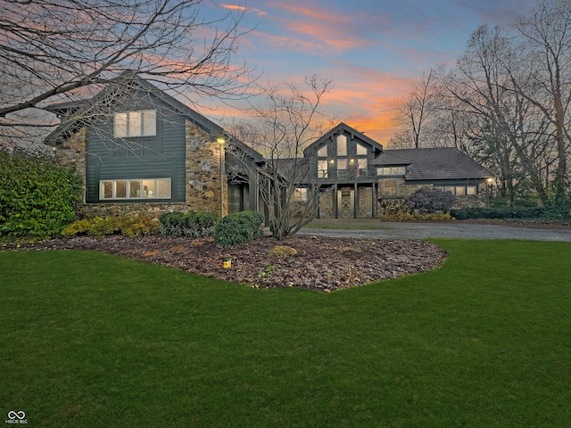 back house at dusk with a lawn